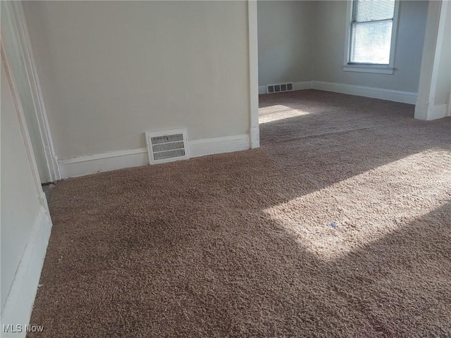 carpeted empty room with visible vents and baseboards