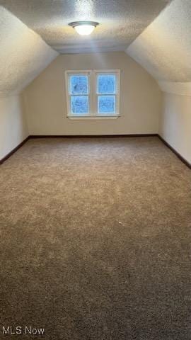 additional living space with light carpet, baseboards, and a textured ceiling