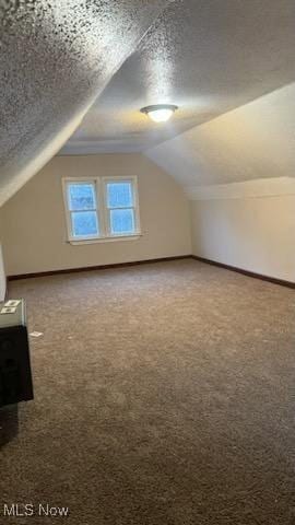 bonus room with carpet flooring, a textured ceiling, and baseboards