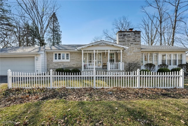 view of front of home with a fenced front yard, a porch, a chimney, stone siding, and an attached garage