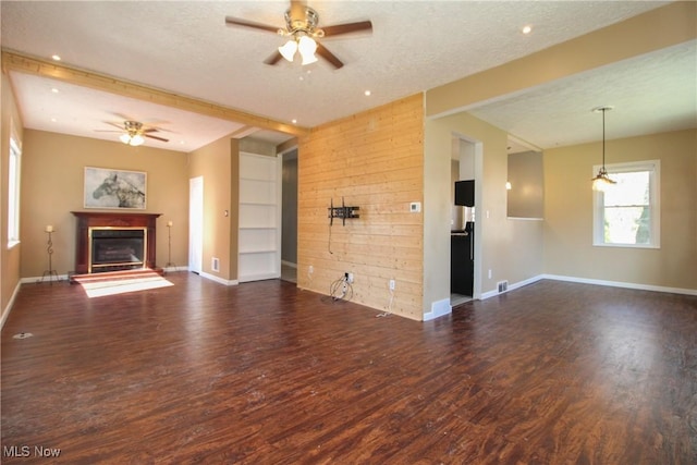 unfurnished living room with a glass covered fireplace, a textured ceiling, wood finished floors, and a ceiling fan