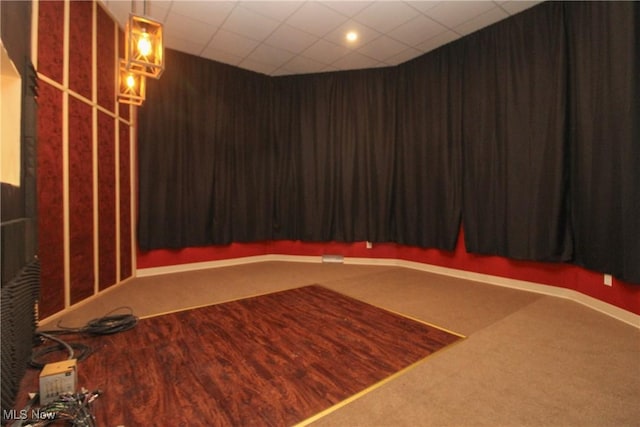 carpeted cinema featuring a paneled ceiling