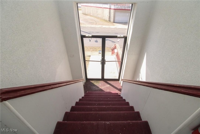 staircase featuring a textured wall