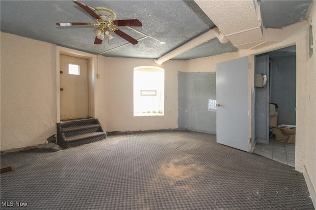 unfurnished room with visible vents, a textured ceiling, ceiling fan, and carpet flooring