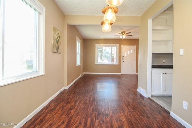 entryway featuring a ceiling fan, baseboards, and dark wood-style flooring