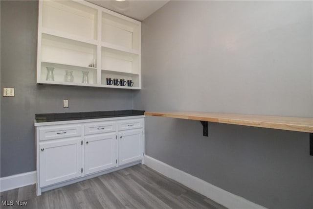 interior space with baseboards and wood finished floors