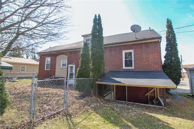 rear view of property featuring fence and brick siding