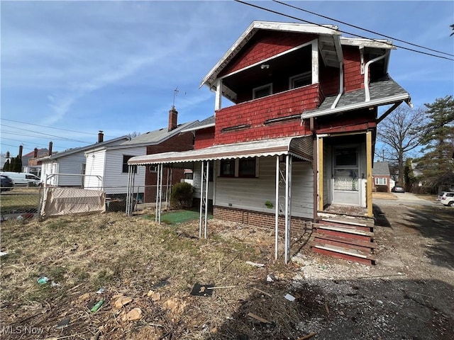 back of house with a balcony and fence