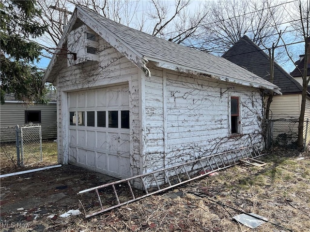 detached garage featuring fence