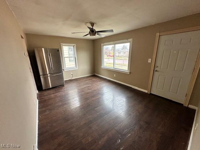 interior space with a wealth of natural light, dark wood finished floors, and a ceiling fan