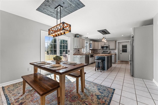 dining space featuring light tile patterned floors, baseboards, an inviting chandelier, and recessed lighting