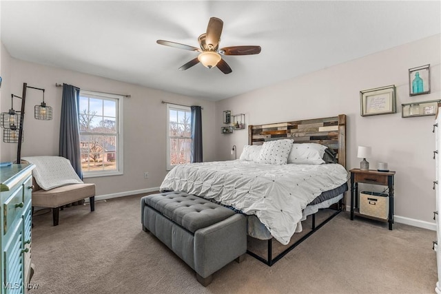 bedroom featuring light carpet, a ceiling fan, and baseboards