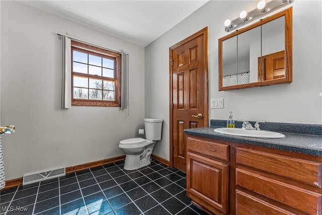 bathroom with vanity, baseboards, visible vents, tile patterned floors, and toilet