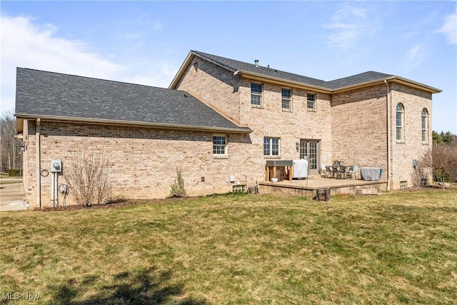 rear view of property featuring a yard, a patio area, and brick siding