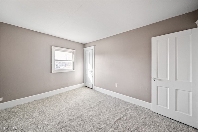 unfurnished bedroom featuring carpet, baseboards, and a closet