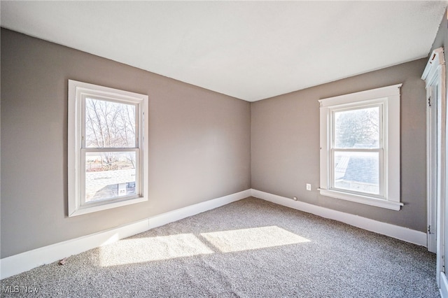 empty room featuring carpet flooring and baseboards