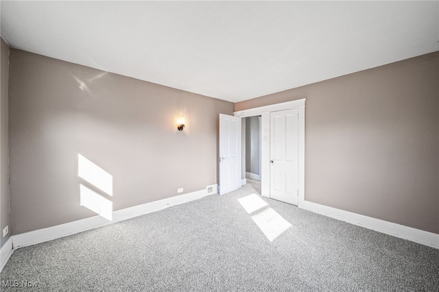 unfurnished bedroom featuring visible vents, baseboards, and carpet