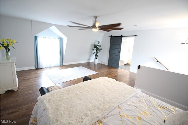 bedroom featuring baseboards, a ceiling fan, a barn door, and wood finished floors