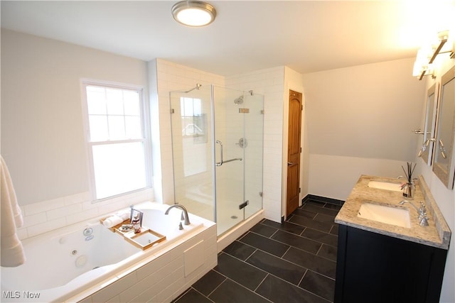 full bathroom featuring a shower stall, a jetted tub, double vanity, tile patterned floors, and a sink