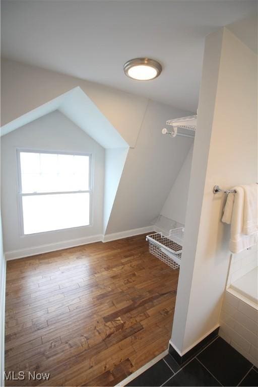 interior space with baseboards, lofted ceiling, and wood finished floors