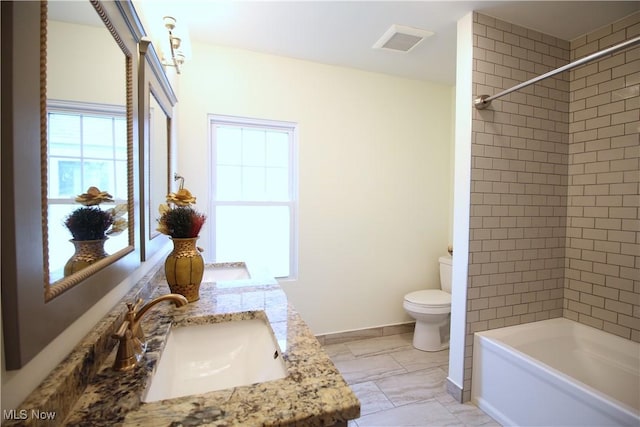 bathroom featuring toilet, a sink, double vanity, baseboards, and shower / bathtub combination