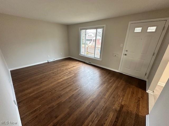 entryway with dark wood-type flooring and baseboards