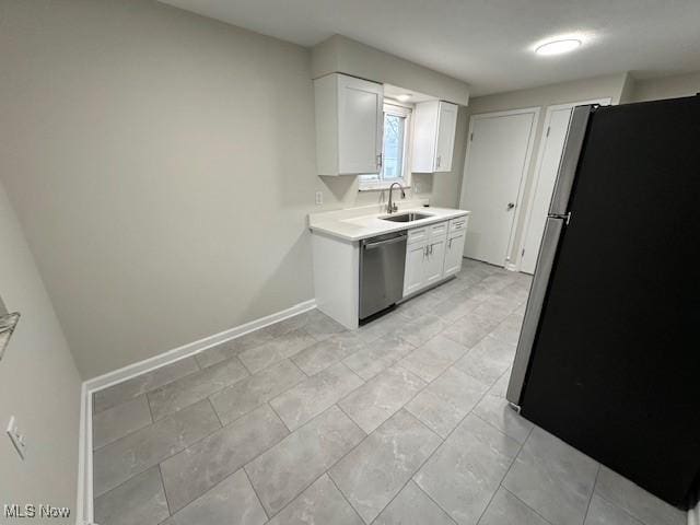 kitchen featuring a sink, stainless steel appliances, white cabinets, and light countertops