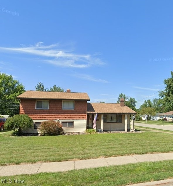 split level home featuring a front lawn and a chimney