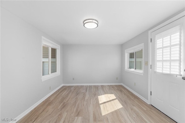 unfurnished room featuring light wood-type flooring and baseboards