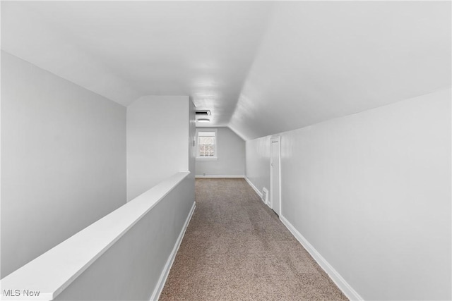 corridor featuring visible vents, an upstairs landing, carpet, baseboards, and vaulted ceiling