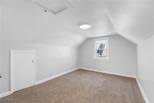 additional living space featuring baseboards, lofted ceiling, and carpet