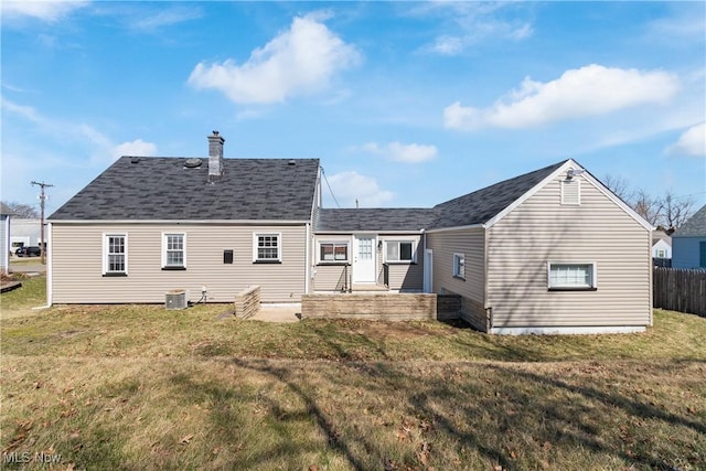 back of property featuring a patio area, a lawn, fence, and roof with shingles