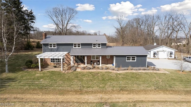 view of front of house featuring a front lawn, covered porch, an outdoor structure, and a chimney