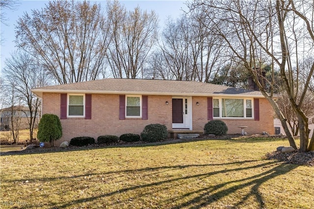 ranch-style home featuring brick siding, central AC unit, and a front lawn