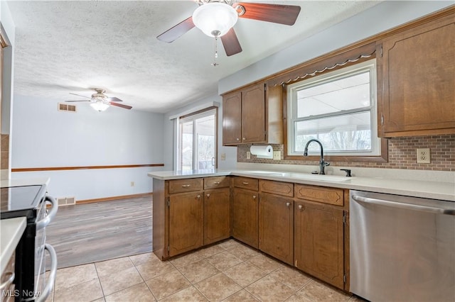 kitchen featuring visible vents, appliances with stainless steel finishes, a peninsula, and a ceiling fan