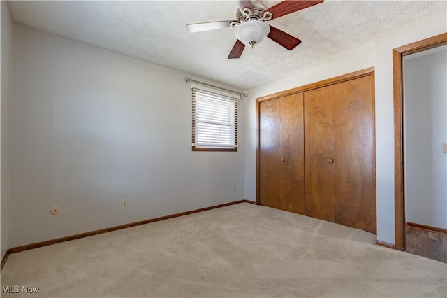 unfurnished bedroom with a textured ceiling, baseboards, and carpet floors