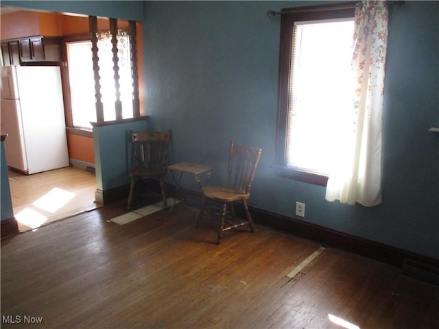 unfurnished dining area featuring light wood-style flooring, a healthy amount of sunlight, and baseboards