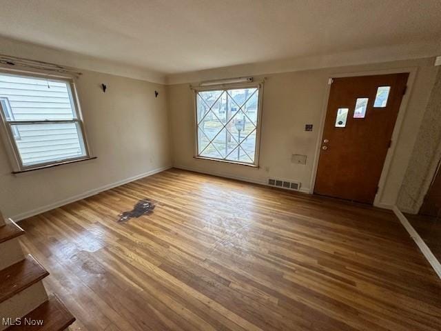 entrance foyer featuring visible vents, baseboards, and wood finished floors