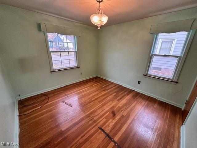 spare room featuring wood finished floors and baseboards