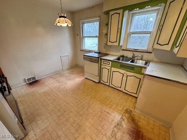 kitchen featuring visible vents, a sink, light countertops, dishwasher, and decorative light fixtures