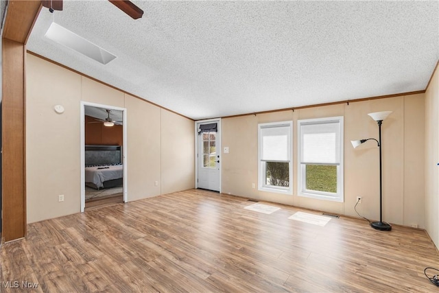 unfurnished living room featuring wood finished floors, crown molding, ceiling fan, and vaulted ceiling