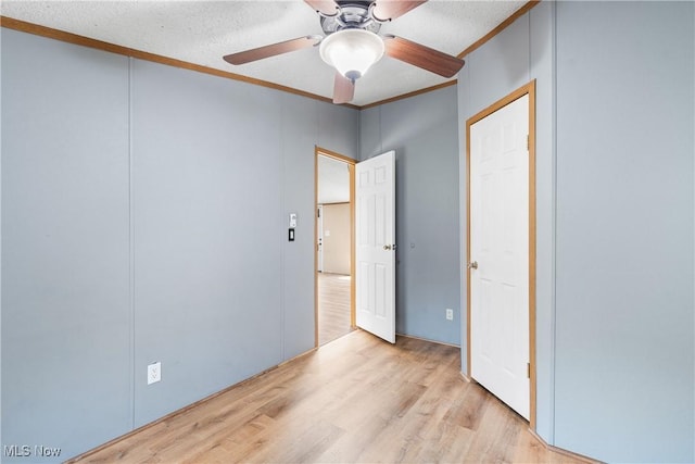 unfurnished bedroom with a textured ceiling, wood finished floors, a ceiling fan, and ornamental molding