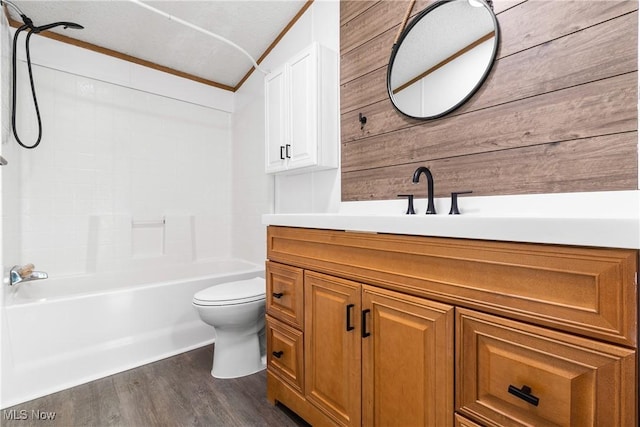 full bath with toilet, wood finished floors, washtub / shower combination, crown molding, and vanity