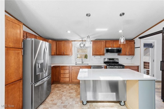 kitchen featuring a sink, backsplash, stainless steel appliances, a barn door, and light countertops