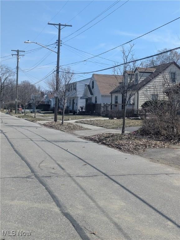 view of street featuring sidewalks, a residential view, and street lights