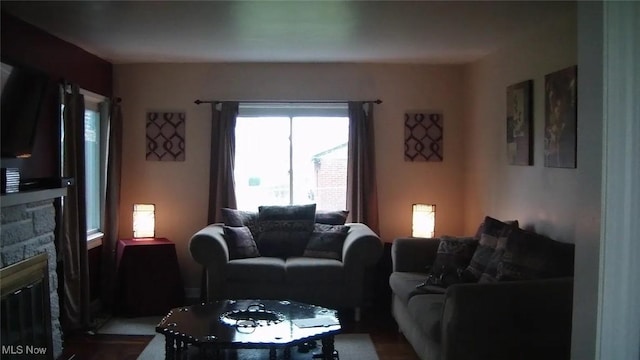 living room featuring a stone fireplace