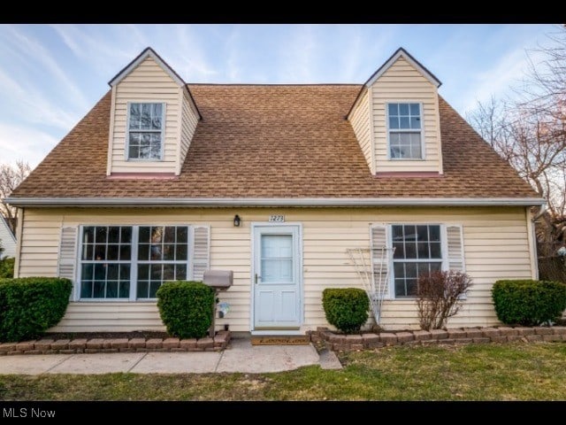 new england style home featuring a shingled roof