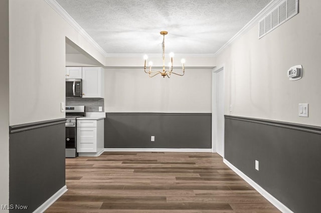 unfurnished dining area featuring visible vents, crown molding, a chandelier, dark wood-style floors, and a textured ceiling