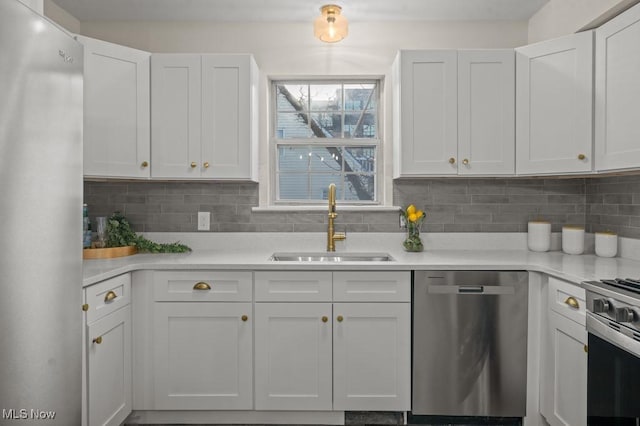 kitchen with a sink, decorative backsplash, appliances with stainless steel finishes, and light countertops