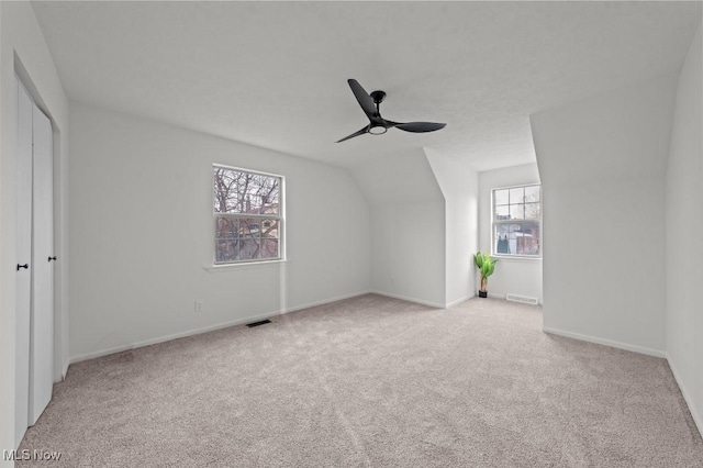 bonus room featuring visible vents, carpet floors, baseboards, ceiling fan, and vaulted ceiling